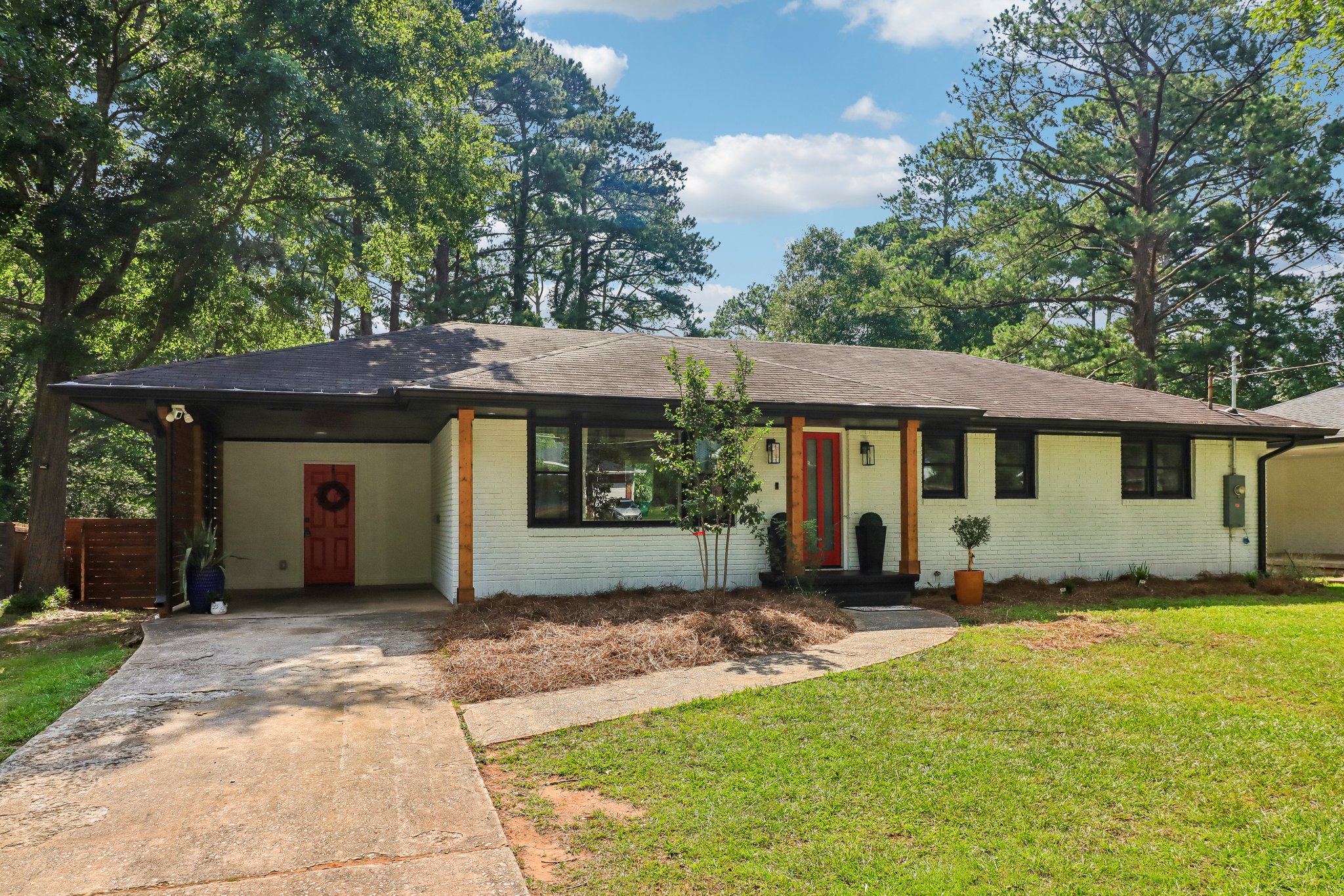 Welcoming approach with a covered carport and bold red entry