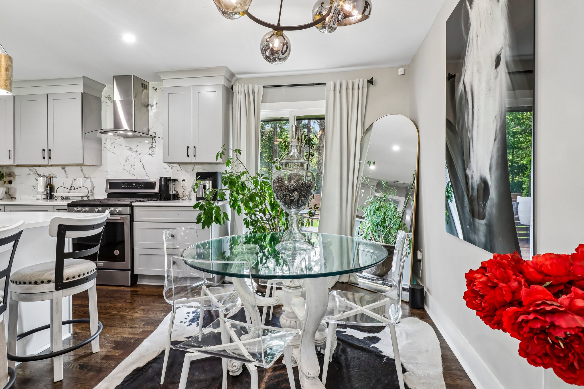 Glass dining table adds an airy counterpoint to the tailored kitchen