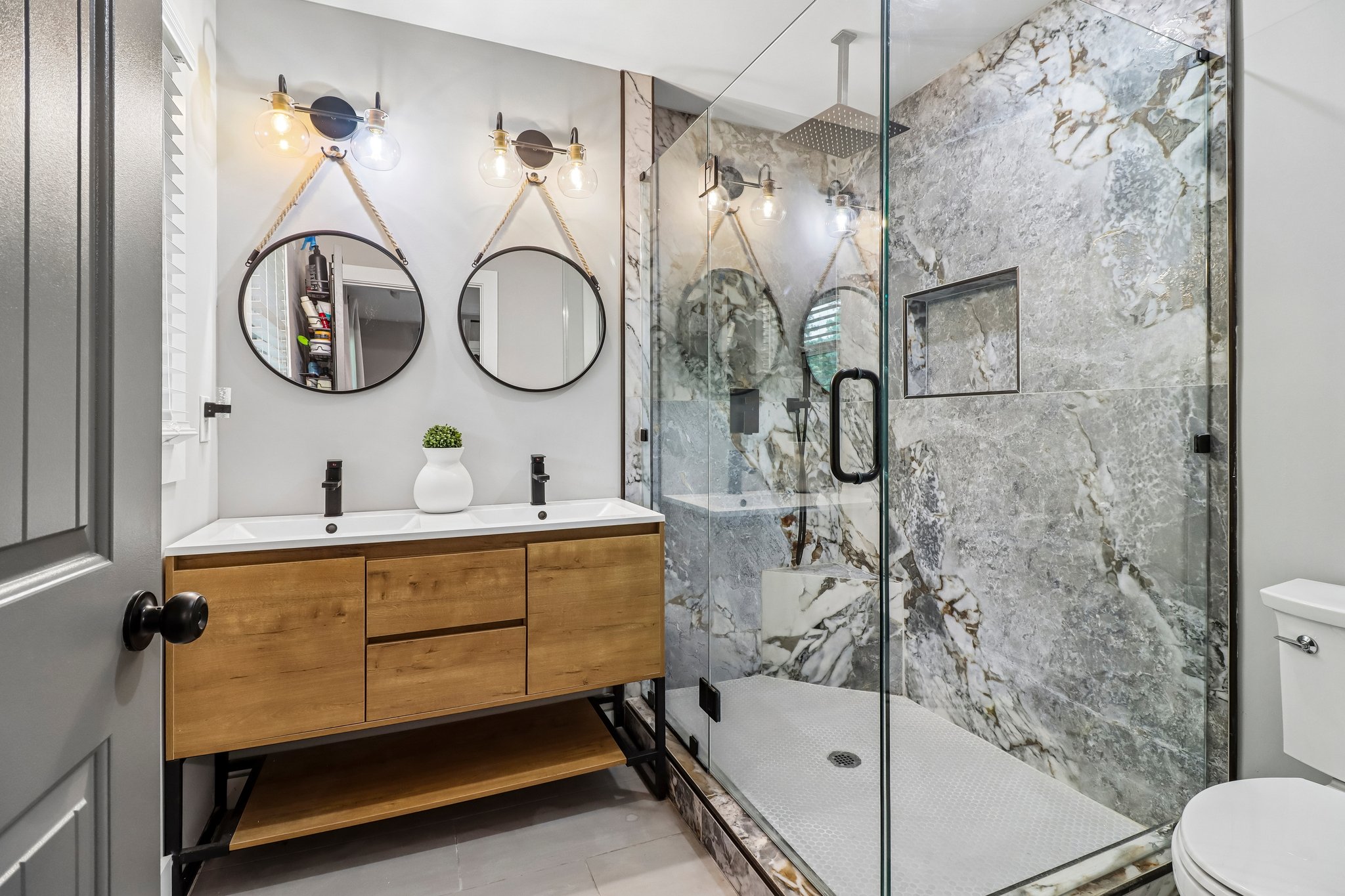 Spa-inspired primary bath with a double vanity and glass shower