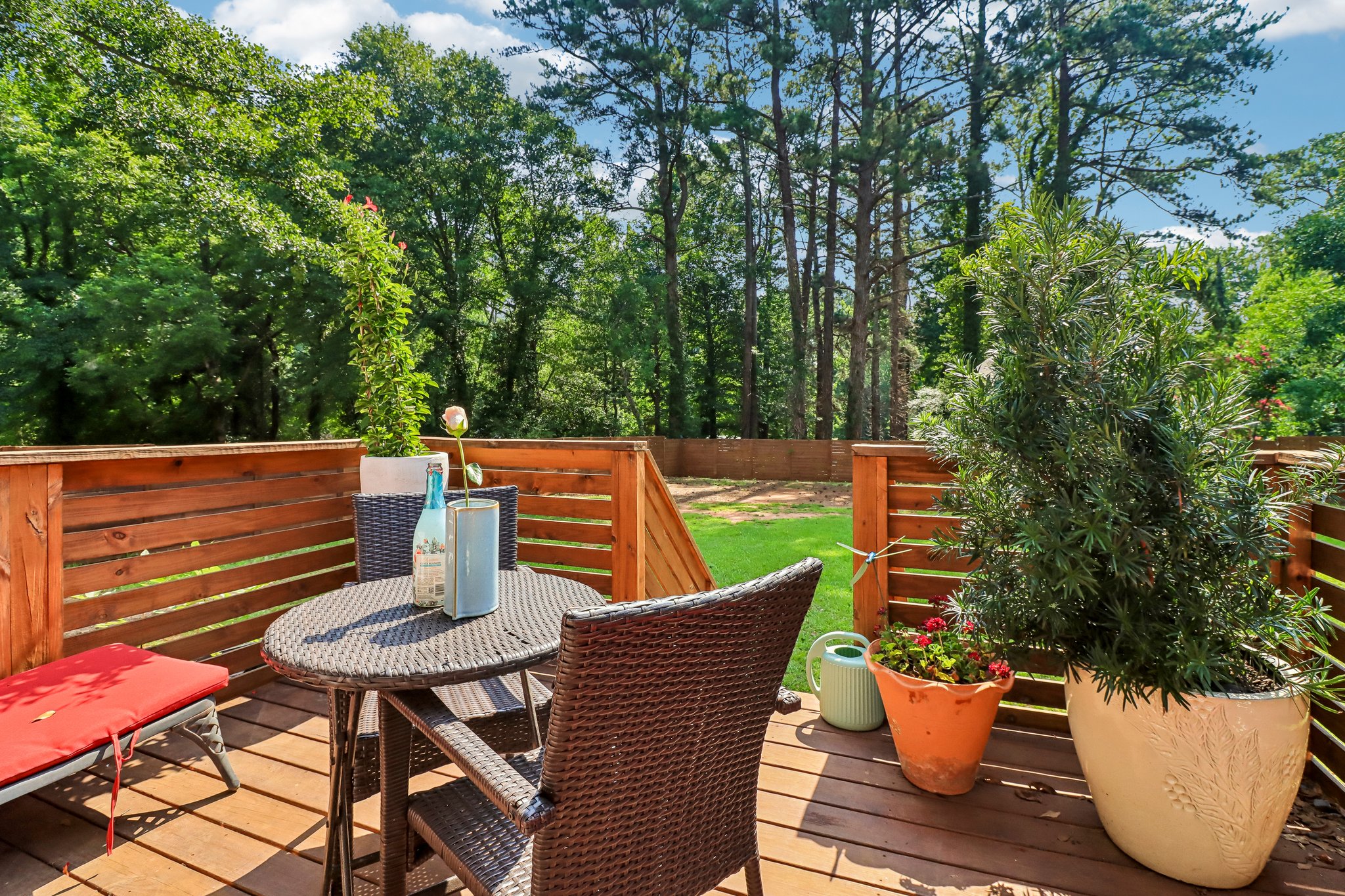 Sunny deck overlooks the expansive fenced backyard