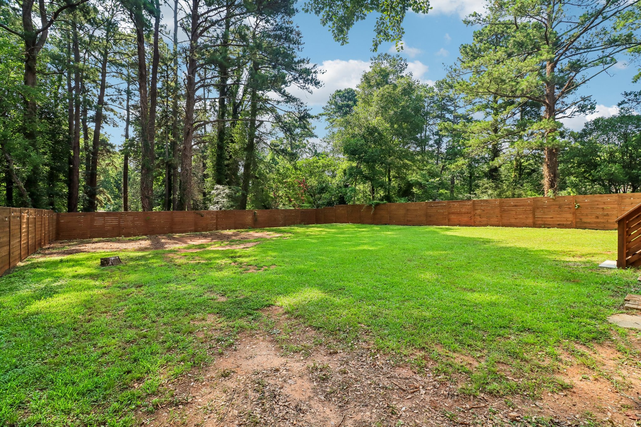 A tranquil tree-lined backdrop gives the yard a private feel